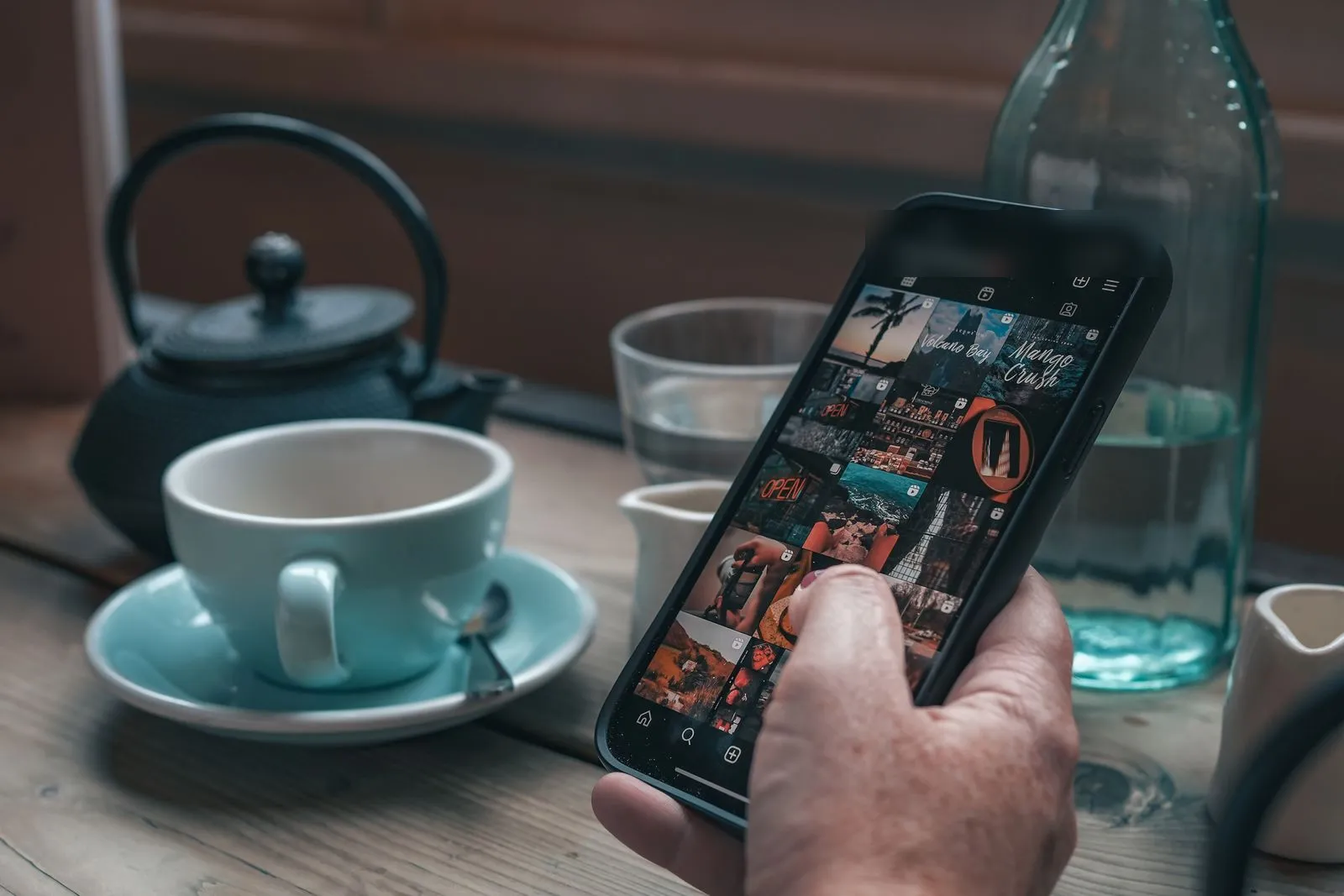 Roka drži telefon z odprto mrežo objav na Instagram profilu